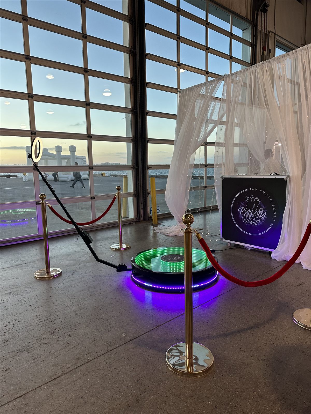 360 Party Wheel spin booth set up at a waterfront hangar venue