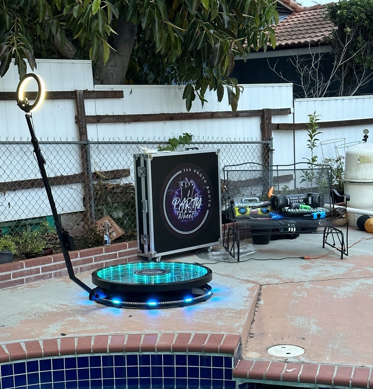 360 Party Wheel spin booth glowing blue poolside at dusk